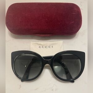 Gucci Cat Eye Black Sunglasses with golden logo temples and a logo on a lense